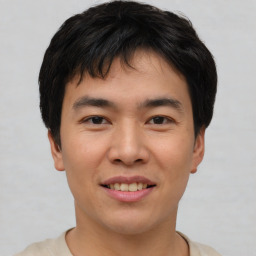 Joyful asian young-adult male with short  brown hair and brown eyes