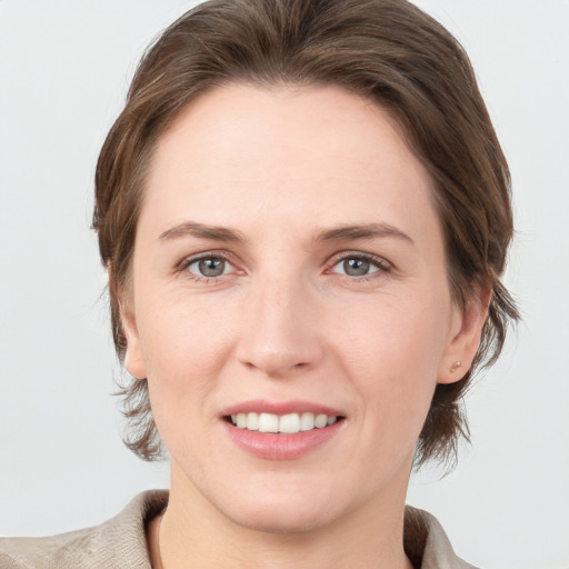 Joyful white young-adult female with medium  brown hair and grey eyes