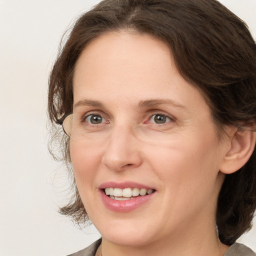 Joyful white adult female with medium  brown hair and brown eyes