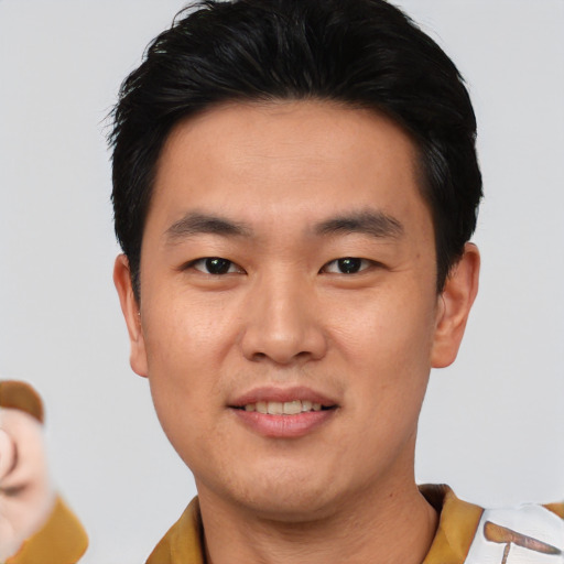 Joyful asian young-adult male with short  black hair and brown eyes
