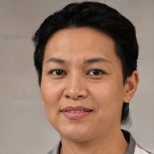 Joyful latino adult female with medium  brown hair and brown eyes