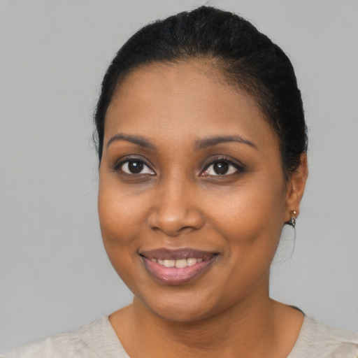 Joyful black young-adult female with medium  brown hair and brown eyes