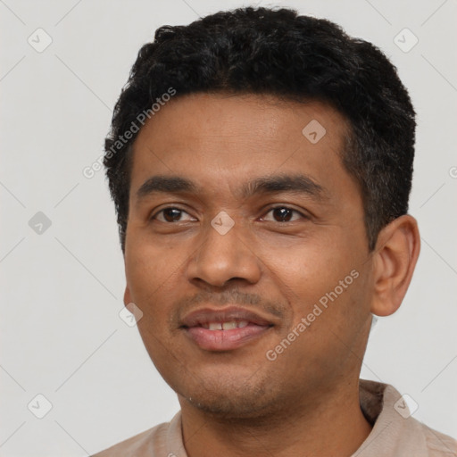 Joyful latino young-adult male with short  black hair and brown eyes