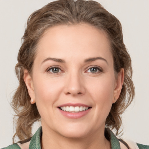 Joyful white young-adult female with medium  brown hair and green eyes