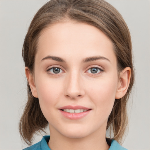 Joyful white young-adult female with medium  brown hair and grey eyes