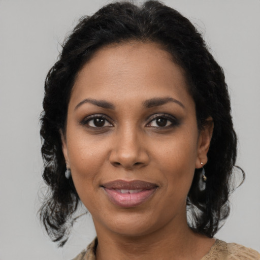 Joyful black young-adult female with long  brown hair and brown eyes