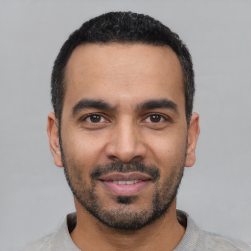 Joyful latino young-adult male with short  black hair and brown eyes