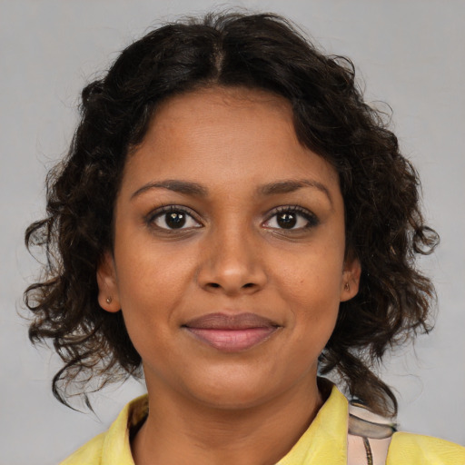 Joyful black young-adult female with medium  brown hair and brown eyes