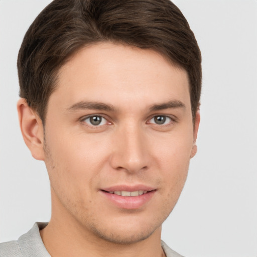 Joyful white young-adult male with short  brown hair and grey eyes