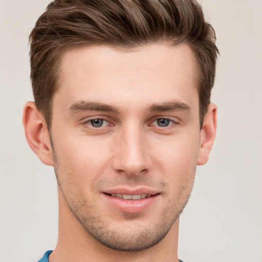 Joyful white young-adult male with short  brown hair and grey eyes