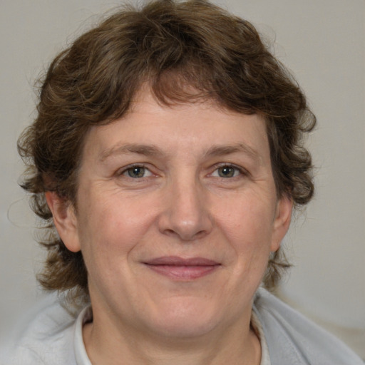 Joyful white adult female with medium  brown hair and blue eyes