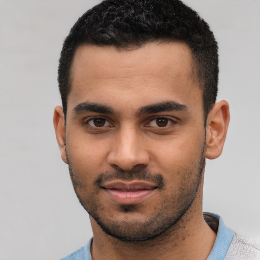 Joyful latino young-adult male with short  black hair and brown eyes