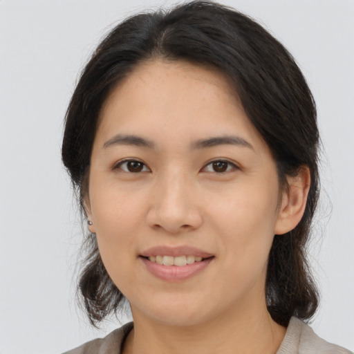 Joyful asian young-adult female with medium  brown hair and brown eyes