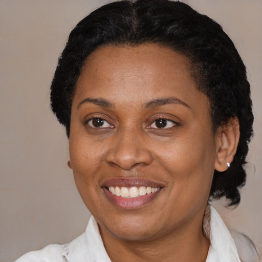 Joyful black adult female with short  black hair and brown eyes