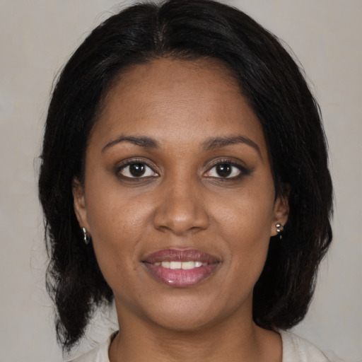 Joyful black young-adult female with medium  brown hair and brown eyes