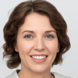 Joyful white young-adult female with medium  brown hair and green eyes