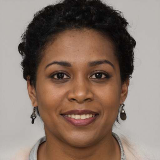 Joyful black young-adult female with short  brown hair and brown eyes