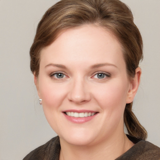 Joyful white young-adult female with medium  brown hair and grey eyes