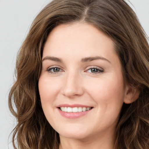 Joyful white young-adult female with long  brown hair and green eyes