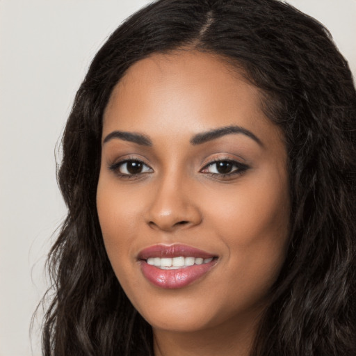 Joyful latino young-adult female with long  black hair and brown eyes