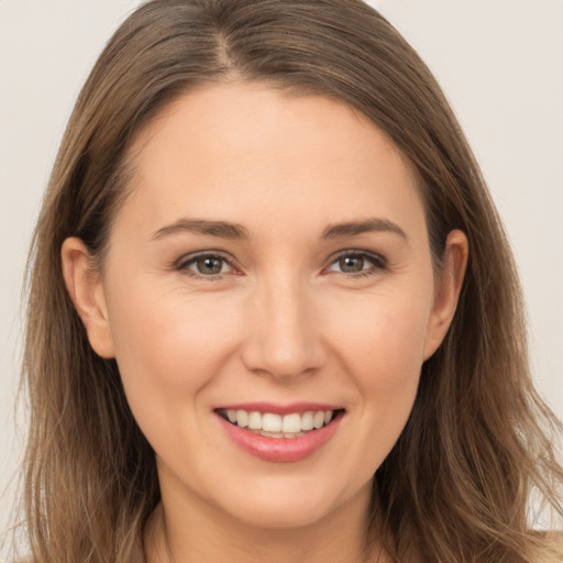 Joyful white young-adult female with long  brown hair and brown eyes