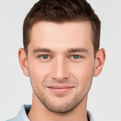 Joyful white young-adult male with short  brown hair and grey eyes