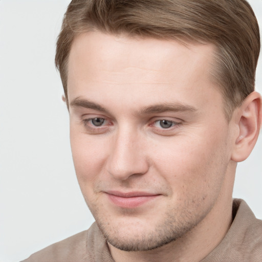 Joyful white young-adult male with short  brown hair and grey eyes