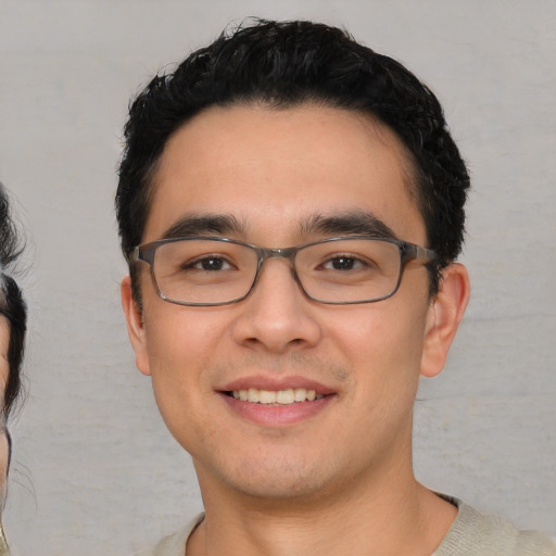 Joyful white young-adult male with short  black hair and brown eyes