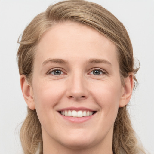 Joyful white young-adult female with medium  brown hair and blue eyes