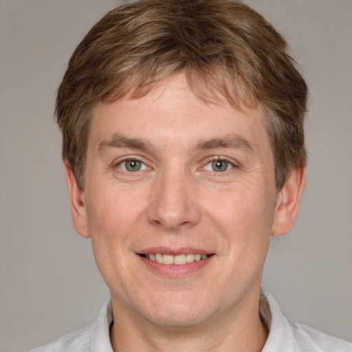 Joyful white adult male with short  brown hair and grey eyes