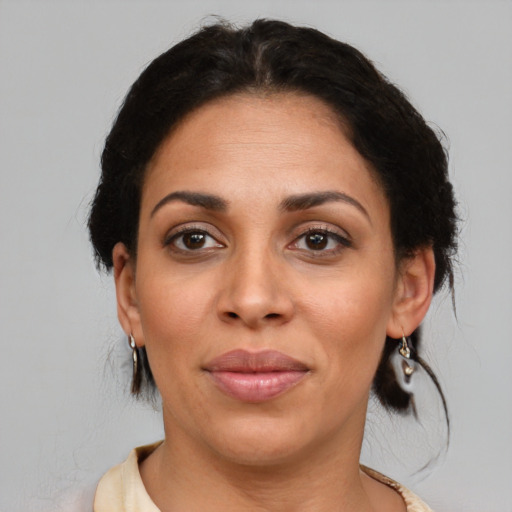 Joyful black adult female with medium  brown hair and brown eyes