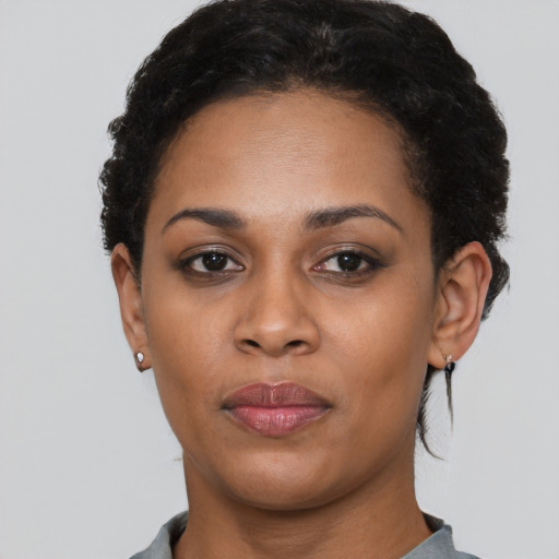 Joyful black adult female with short  black hair and brown eyes