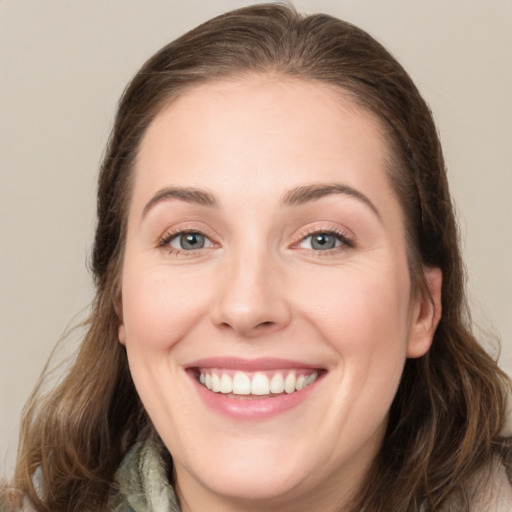 Joyful white young-adult female with medium  brown hair and green eyes