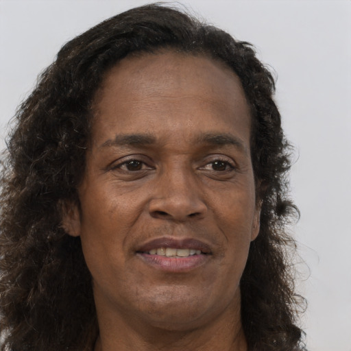 Joyful black adult male with long  brown hair and brown eyes