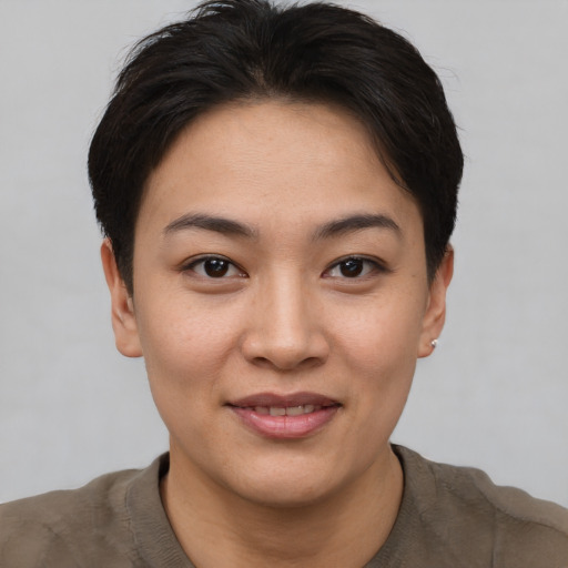 Joyful asian young-adult female with short  brown hair and brown eyes