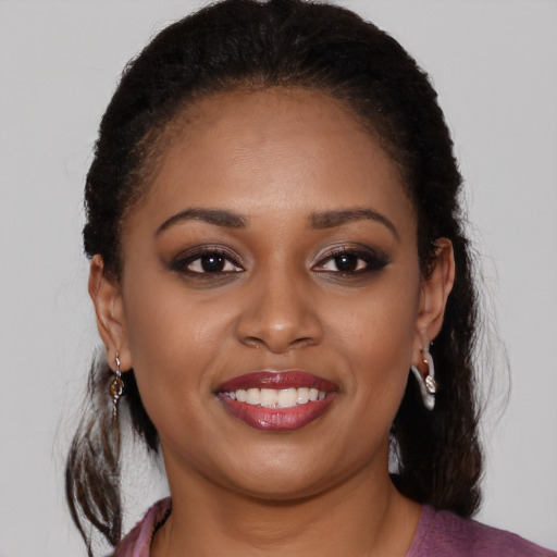 Joyful black young-adult female with long  brown hair and brown eyes