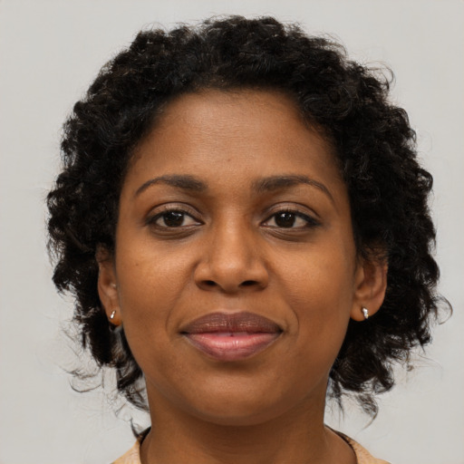 Joyful black young-adult female with medium  brown hair and brown eyes