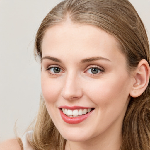 Joyful white young-adult female with long  brown hair and blue eyes