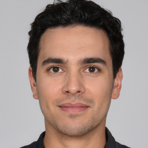 Joyful white young-adult male with short  black hair and brown eyes