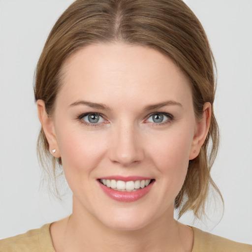 Joyful white young-adult female with medium  brown hair and blue eyes