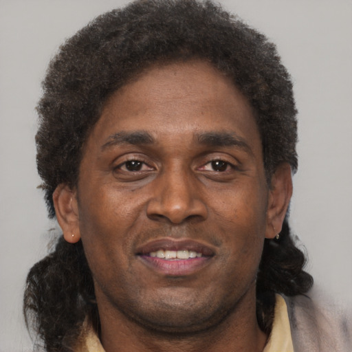 Joyful black adult male with short  brown hair and brown eyes