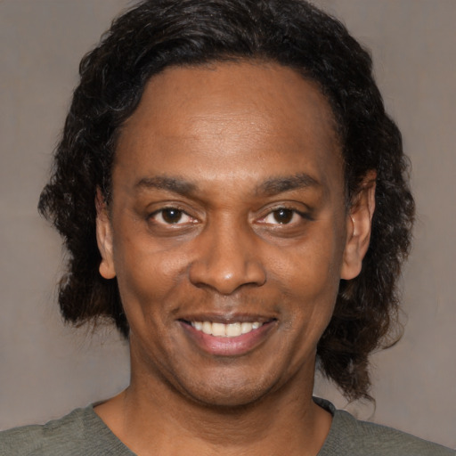 Joyful black young-adult male with medium  black hair and brown eyes