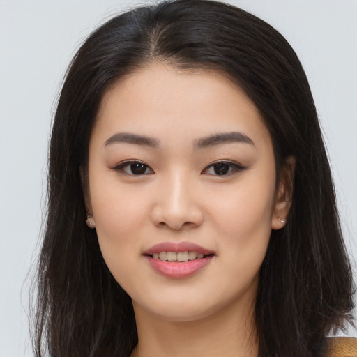 Joyful asian young-adult female with long  brown hair and brown eyes