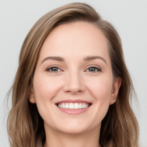 Joyful white young-adult female with long  brown hair and grey eyes