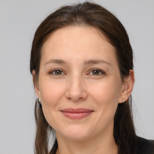 Joyful white adult female with long  brown hair and brown eyes