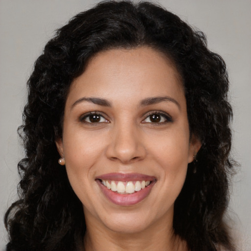 Joyful latino young-adult female with long  brown hair and brown eyes