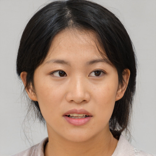Joyful asian young-adult female with medium  brown hair and brown eyes