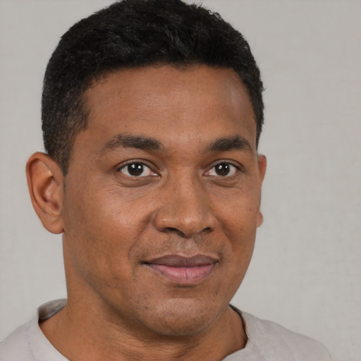 Joyful black young-adult male with short  brown hair and brown eyes