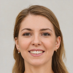 Joyful white young-adult female with long  brown hair and green eyes