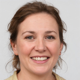 Joyful white adult female with medium  brown hair and grey eyes